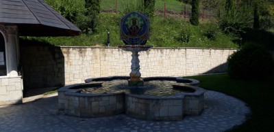 Der Brunnen im Schatten der Kirche auf dem Hügel